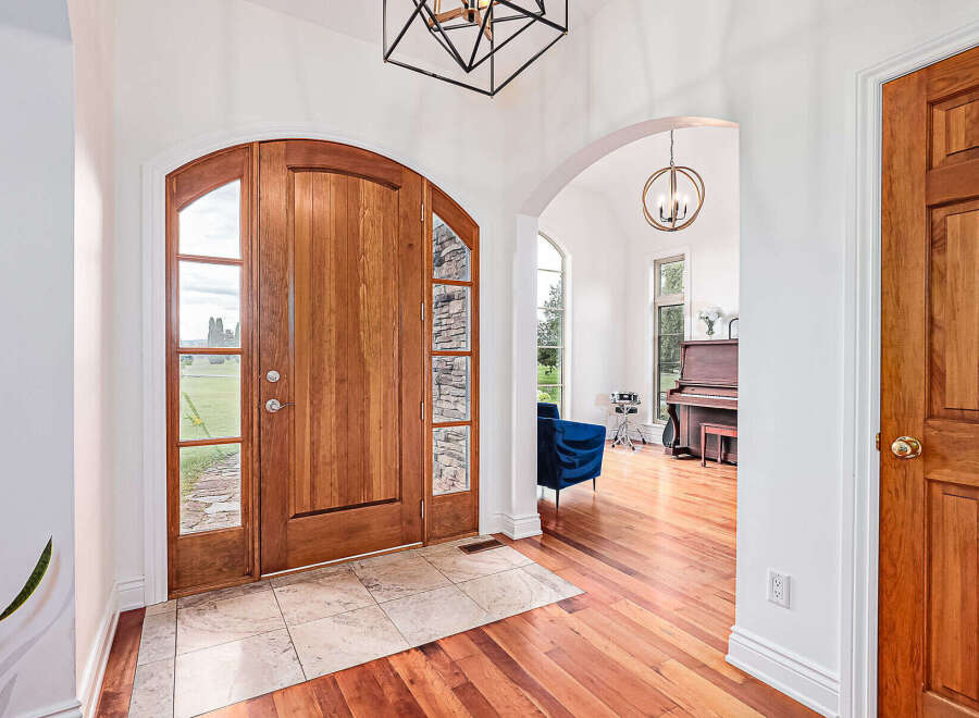 Step into luxury with this stunning property, featuring a grand entrance with a beautiful wooden door and elegant archways.