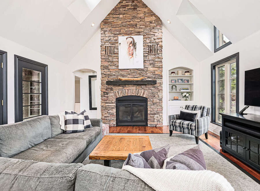 Step into luxury with this stunning living room, featuring a striking stone fireplace as the centerpiece.