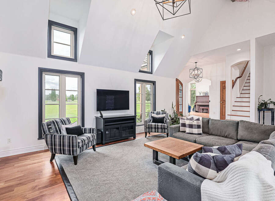 Step into luxury with this stunning living room! Featuring a modern design with high ceilings, large windows, and a cozy fireplace, this space is perfect for both relaxation and entertaining.