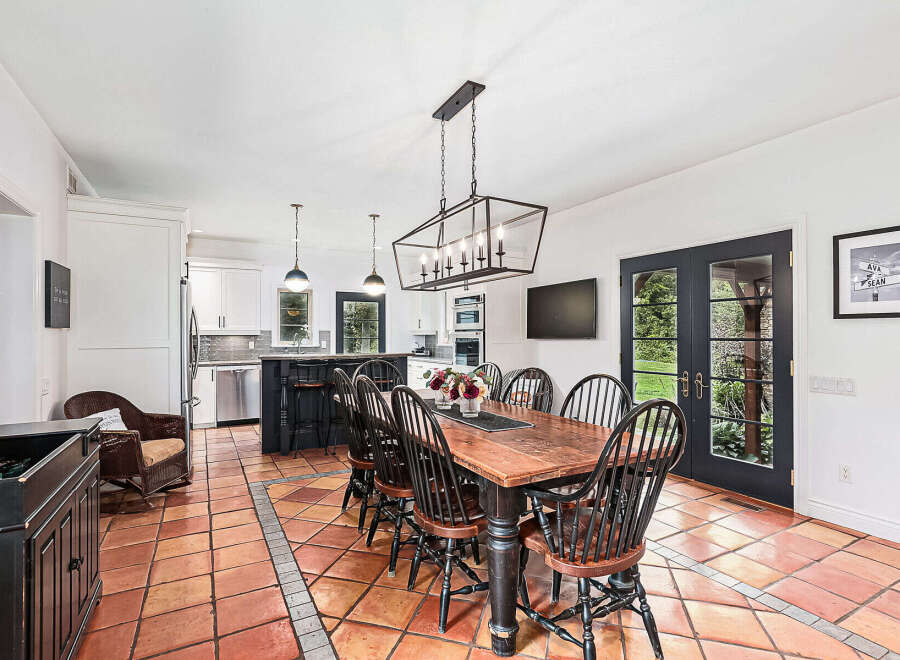 This stunning dining room features a rustic wooden table and elegant black chairs, perfect for hosting gatherings.