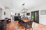 This stunning dining room features a rustic wooden table and elegant black chairs, perfect for hosting gatherings.