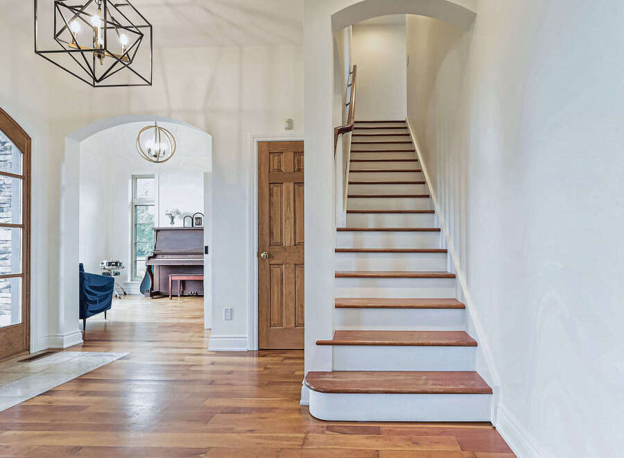 Step into luxury with this stunning home featuring a grand staircase and elegant hardwood floors.