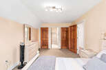 Discover the charm of this inviting bedroom, featuring a warm and welcoming ambiance.