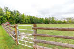 Discover the tranquility of this stunning property, featuring a beautifully crafted wooden fence that frames the lush green pasture.