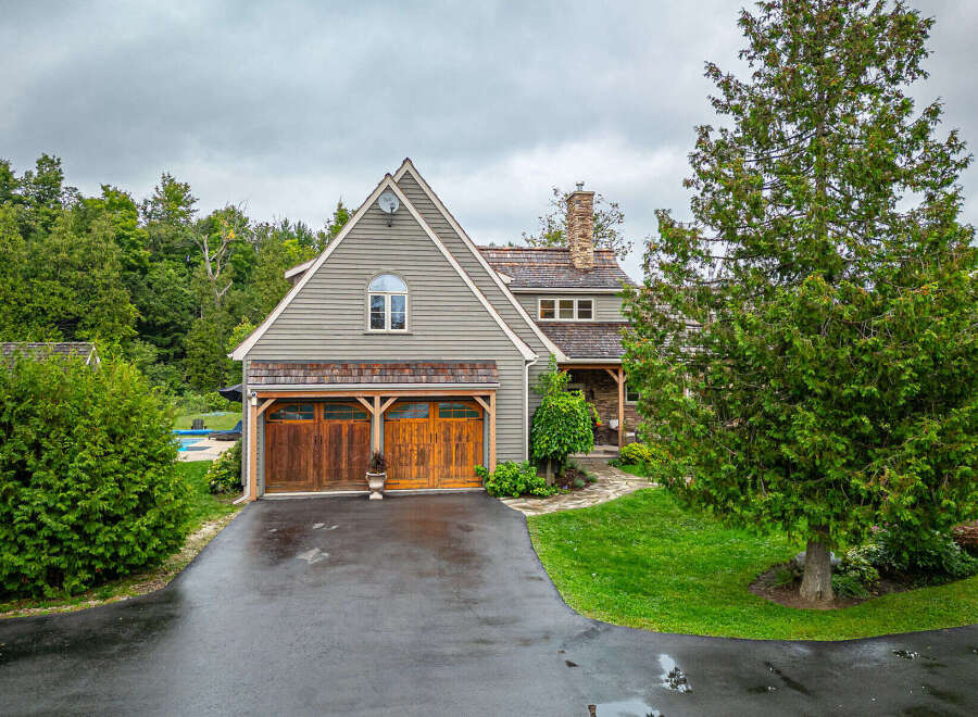 This stunning property boasts a charming exterior with a combination of wood and stone elements, creating a warm and inviting atmosphere.