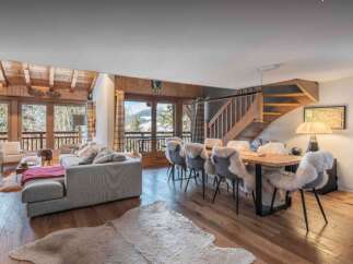 Experience luxury living in this stunning chalet, featuring a spacious living area with a cozy fireplace and large windows offering breathtaking mountain views.