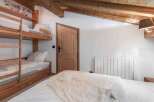 This cozy bedroom features a rustic wooden bunk bed, perfect for accommodating guests or family.