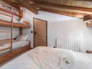 This cozy bedroom features a rustic wooden bunk bed, perfect for accommodating guests or family.