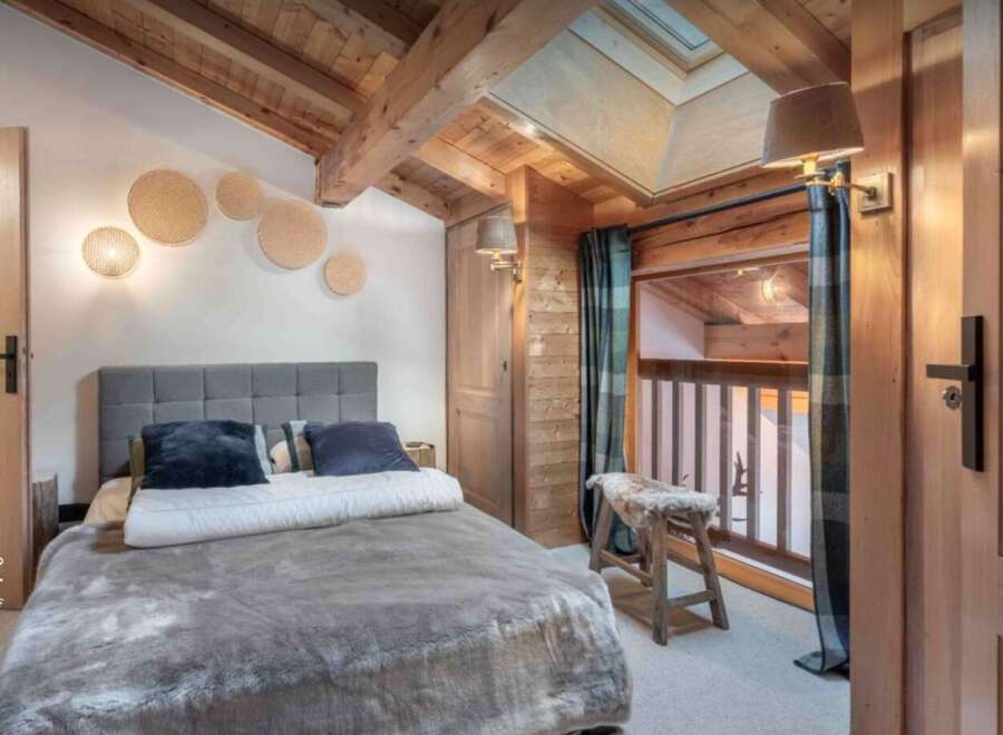 Experience the charm of this cozy bedroom, featuring a rustic wooden ceiling and walls that exude warmth.