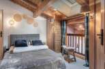Experience the charm of this cozy bedroom, featuring a rustic wooden ceiling and walls that exude warmth.