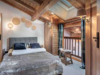 Experience the charm of this cozy bedroom, featuring a rustic wooden ceiling and walls that exude warmth.
