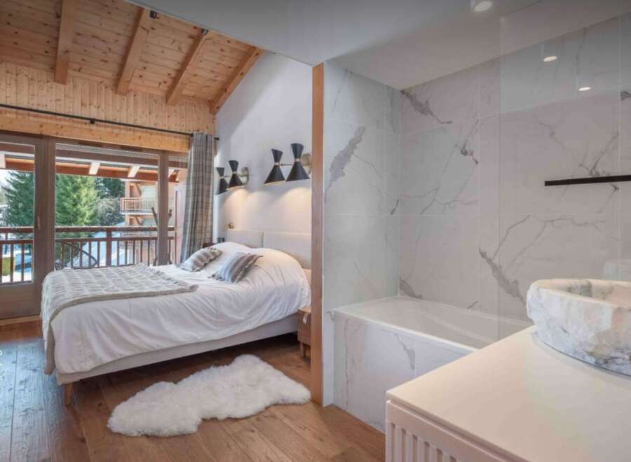 Experience luxury living in this stunning property, featuring a beautifully designed bedroom with a cozy bed and a stylish bathroom.