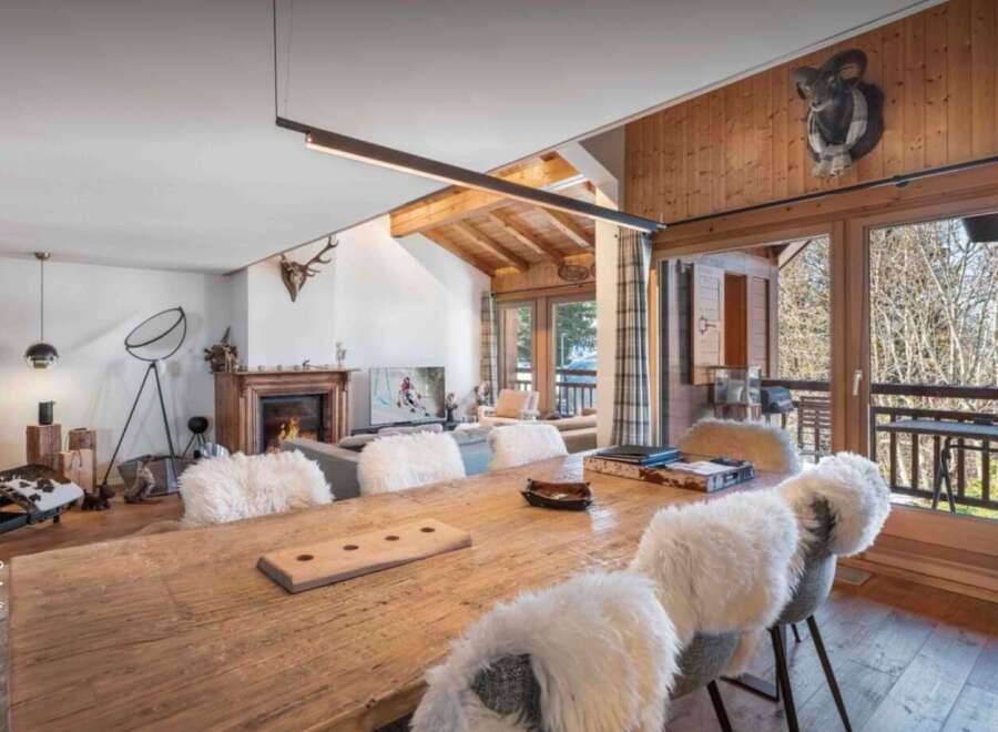 Experience luxury living in this stunning chalet, featuring a rustic wooden dining table perfect for gatherings.