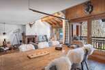 Experience luxury living in this stunning chalet, featuring a rustic wooden dining table perfect for gatherings.