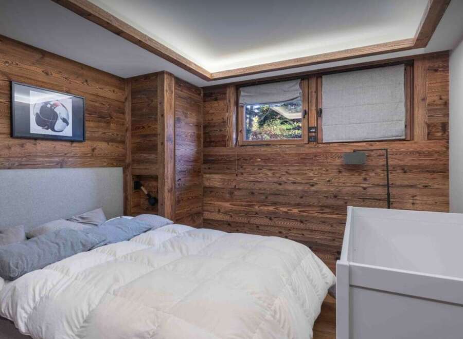 This cozy bedroom features stunning wood paneling, creating a warm and inviting atmosphere.