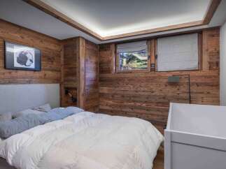 This cozy bedroom features stunning wood paneling, creating a warm and inviting atmosphere.