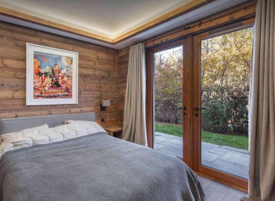 Experience the tranquility of this stunning bedroom, featuring rustic wood paneling and a serene ambiance.