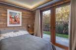 Experience the tranquility of this stunning bedroom, featuring rustic wood paneling and a serene ambiance.