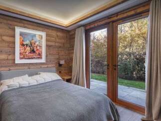 Experience the tranquility of this stunning bedroom, featuring rustic wood paneling and a serene ambiance.