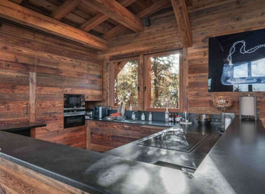 This stunning kitchen showcases rustic elegance with its wooden walls and ceiling, creating a warm and inviting atmosphere.