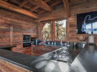 This stunning kitchen showcases rustic elegance with its wooden walls and ceiling, creating a warm and inviting atmosphere.
