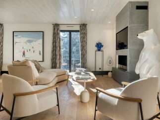 Experience luxury living in this stunning property, featuring a modern living room with a cozy fireplace and elegant decor.