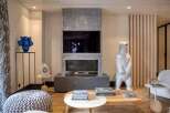 This stunning living room boasts a modern fireplace with a built-in TV, creating a cozy focal point.