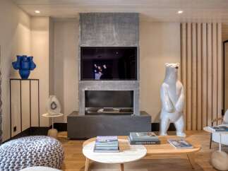 This stunning living room boasts a modern fireplace with a built-in TV, creating a cozy focal point.