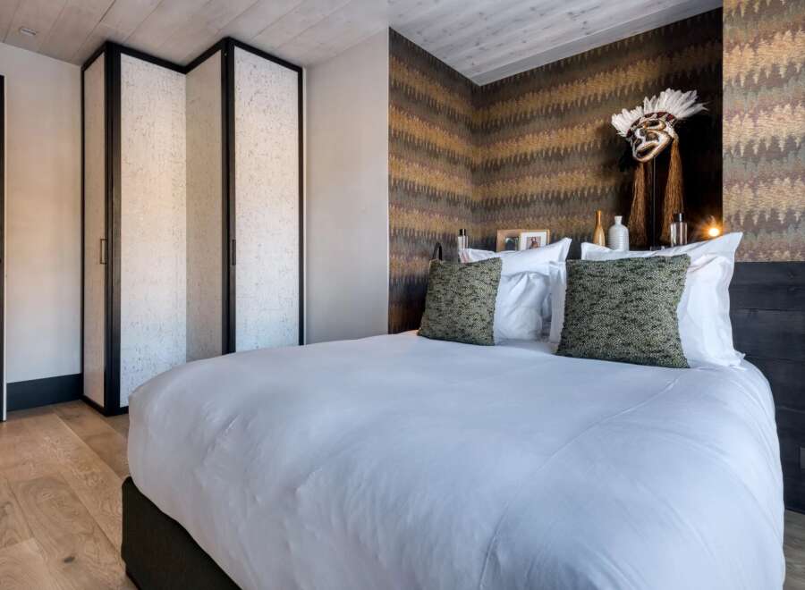 This luxurious bedroom showcases a blend of modern design and rustic charm, perfect for a relaxing retreat.