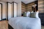 This luxurious bedroom showcases a blend of modern design and rustic charm, perfect for a relaxing retreat.