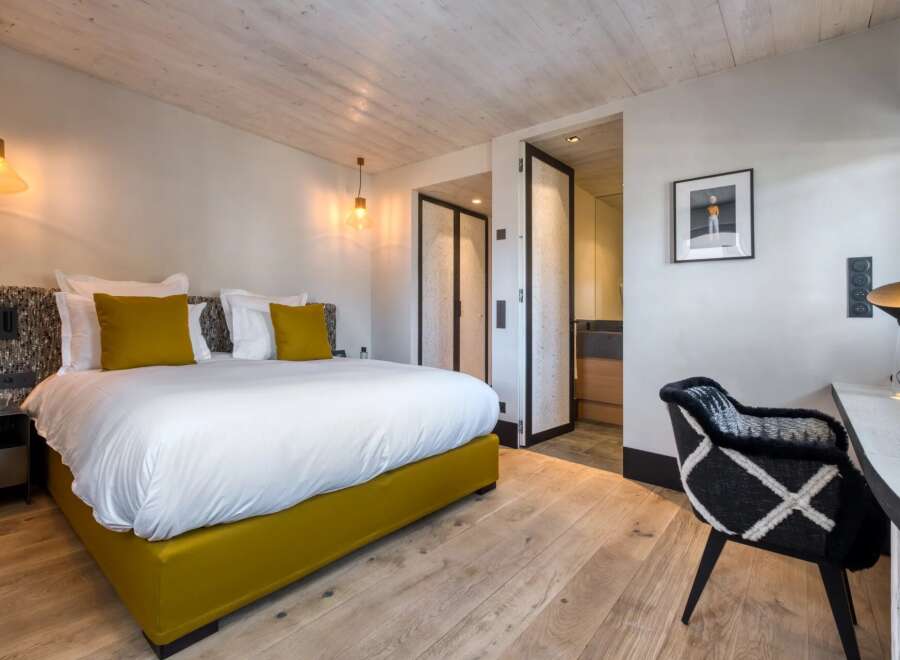 Experience luxury in this stunning bedroom featuring a plush bed with vibrant yellow accents.