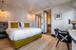 Experience luxury in this stunning bedroom featuring a plush bed with vibrant yellow accents.
