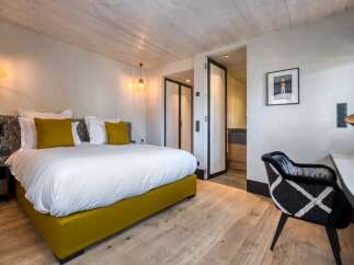 Experience luxury in this stunning bedroom featuring a plush bed with vibrant yellow accents.