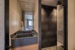 Experience luxury in this modern bathroom featuring a sleek concrete sink and a spacious walk-in shower.