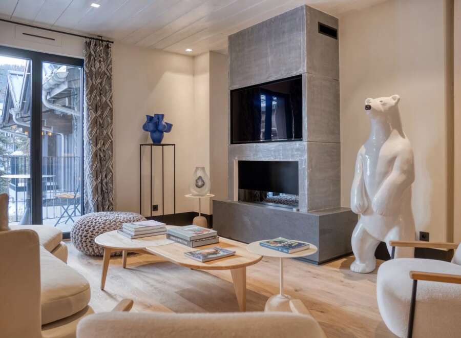 Experience luxury living in this stunning property, featuring a modern fireplace and a unique polar bear sculpture.