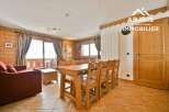 Discover the charm of this inviting property, featuring a cozy living space with wooden accents and a dining area perfect for gatherings.