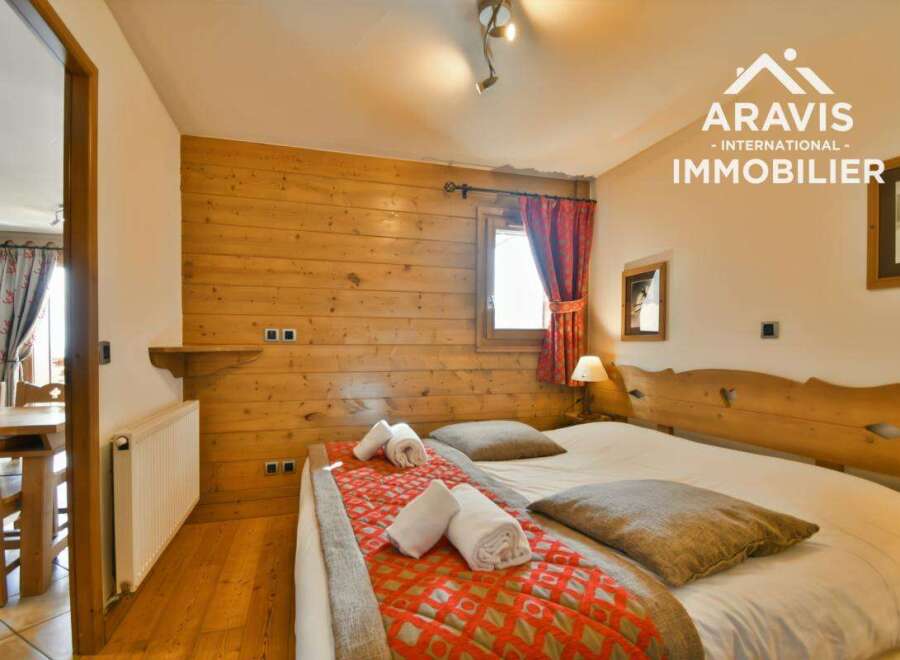 Discover the charm of this cozy bedroom, featuring warm wooden accents and a comfortable bed.