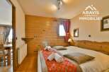 Discover the charm of this cozy bedroom, featuring warm wooden accents and a comfortable bed.