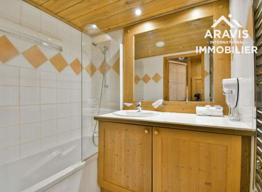Discover the charm of this bathroom, featuring a stylish wooden vanity and a sleek glass shower enclosure.
