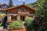 Experience mountain living in this charming wooden chalet, featuring a stone facade and multiple balconies offering scenic views.