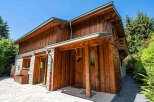 Experience rustic charm in this wooden chalet, featuring a stone base and a welcoming covered entrance.