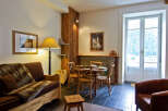 Step into this charming property, featuring a cozy living space with a rustic wooden accent wall.