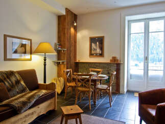 Step into this charming property, featuring a cozy living space with a rustic wooden accent wall.