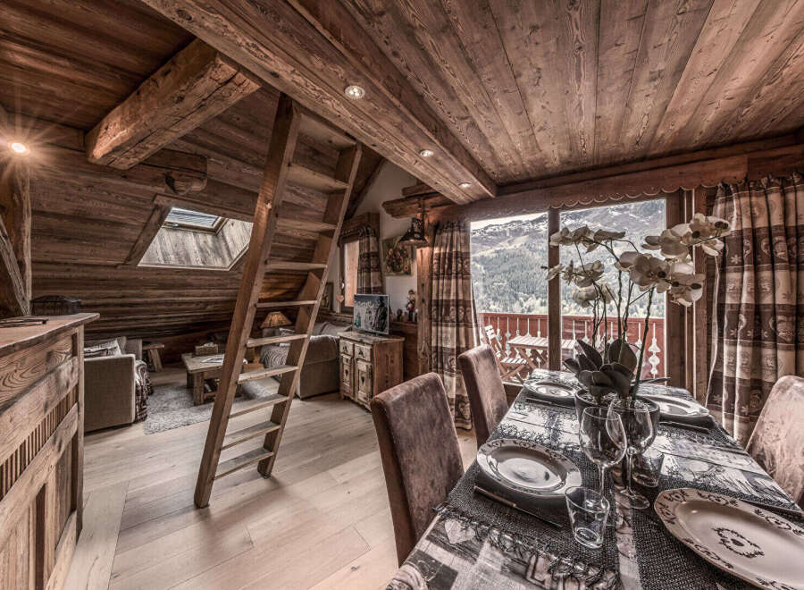 Experience the charm of this stunning chalet, featuring a cozy dining area with a view.