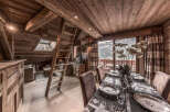 Experience the charm of this stunning chalet, featuring a cozy dining area with a view.