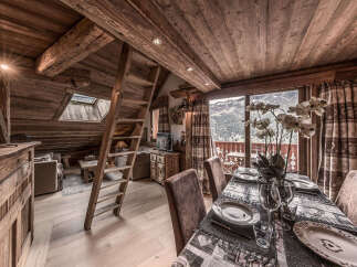 Experience the charm of this stunning chalet, featuring a cozy dining area with a view.
