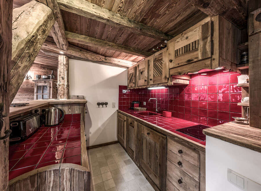 Step into rustic charm with this stunning kitchen! Featuring beautiful wooden cabinetry and a vibrant red tile backsplash, this space exudes warmth and character.