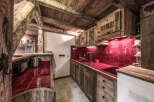 Step into rustic charm with this stunning kitchen! Featuring beautiful wooden cabinetry and a vibrant red tile backsplash, this space exudes warmth and character.
