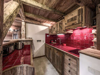 Step into rustic charm with this stunning kitchen! Featuring beautiful wooden cabinetry and a vibrant red tile backsplash, this space exudes warmth and character.