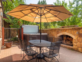 Enjoy outdoor living at its finest with this stunning patio featuring a luxurious hot tub and a cozy fireplace.